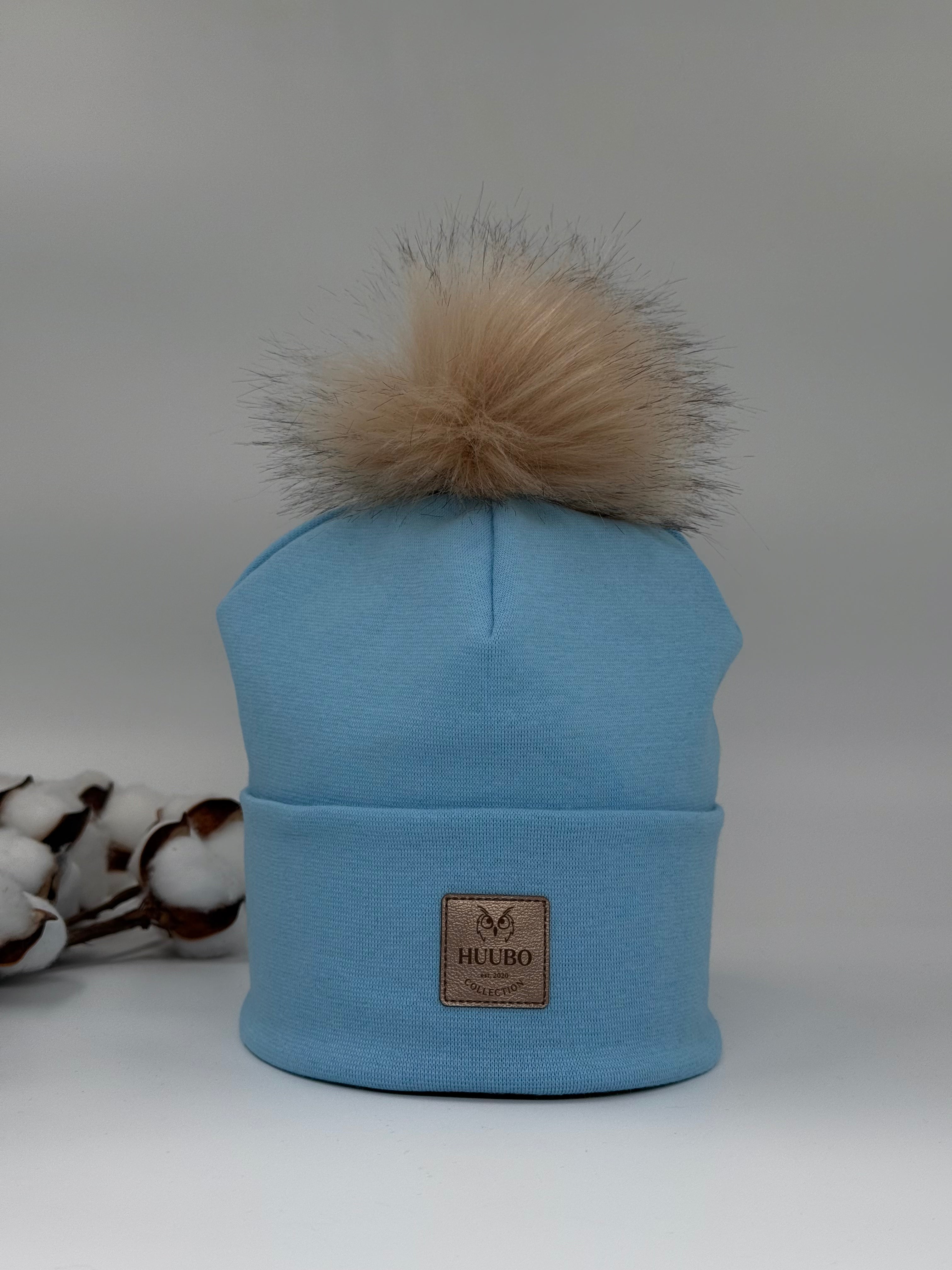 Kotimainen pipo. Tupsu,Huubon kullanhohtoinen logo edessä.