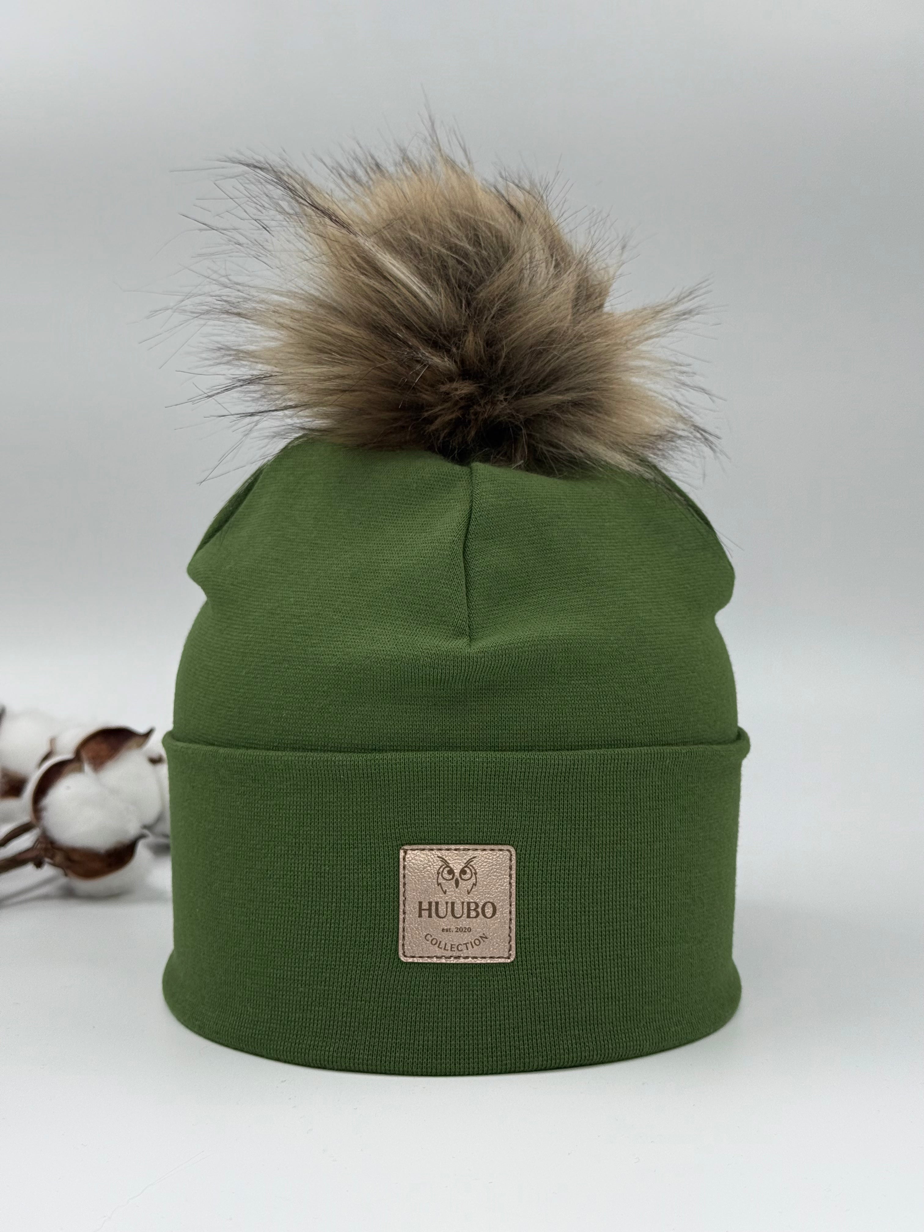 Vihreä puuvillapipo naisille, yksi tupsu. Taitteellinen pipo Huubon kullanhohtoisella logolla.